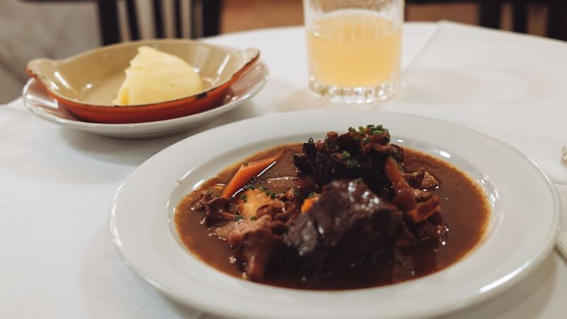 A dish of braised beef with mashed potato on a white tablecloth in a traditional Austrian restaurant