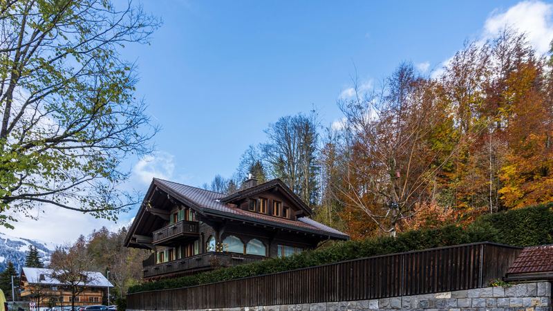 A traditional chalet among autumn trees in Gstaad