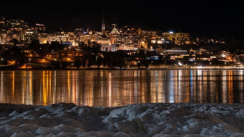 The lights of St. Moritz reflected in its lake at night