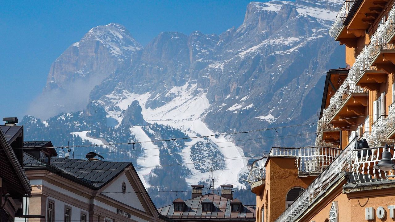 The town hall and grand hotels of Cortina d'Ampezzo below the snowy Olympic slopes of the Tofane