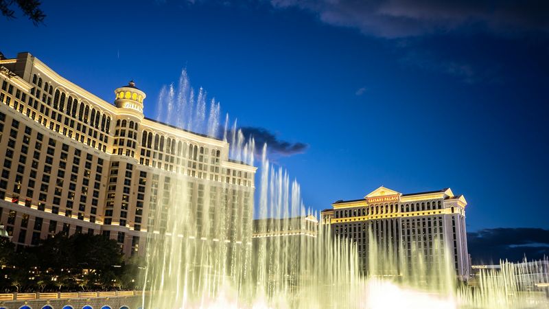 The Bellagio fountains at dusk, with Caesars Palace beyond