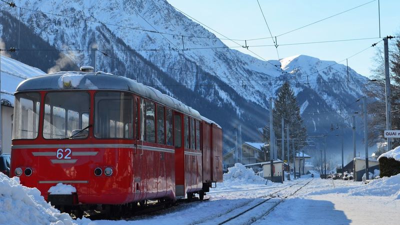 A red mountain train in fresh snow at a station in the Chamonix valley