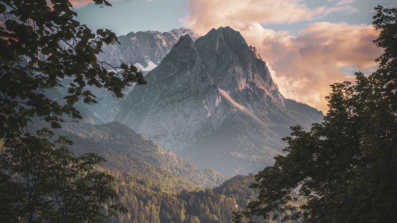 The Waxenstein and the Wetterstein glowing at sunset, framed by the trees above Garmisch