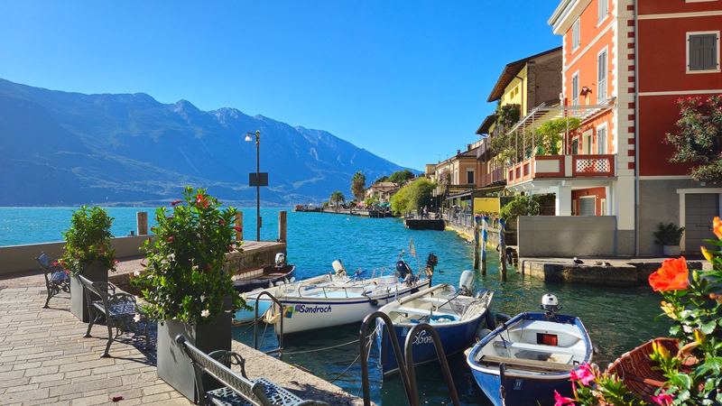 Boats, flowers and coloured houses on the harbour of Limone sul Garda
