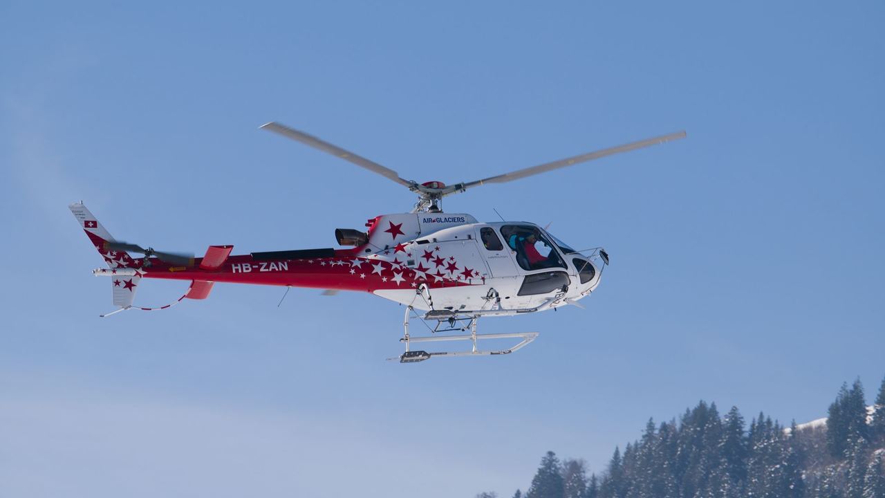 An Air Glaciers helicopter in a winter sky