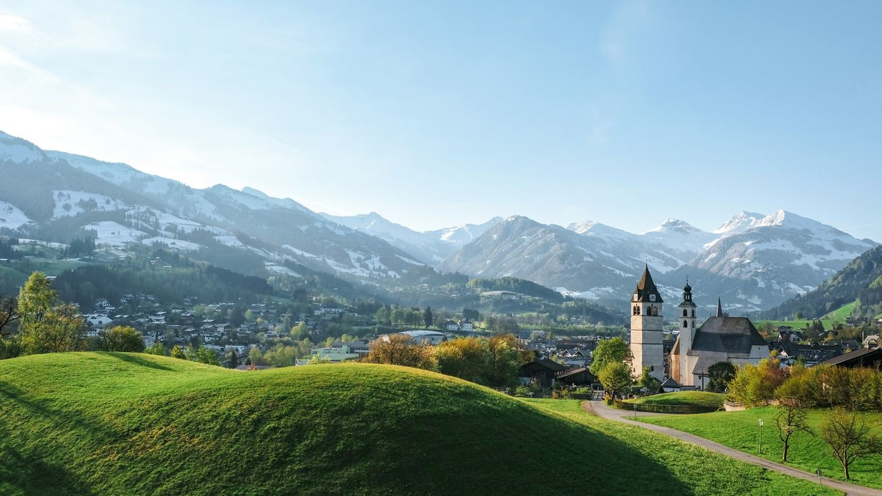 The parish church of Kitzbühel in spring, below the snow-capped Kitzbühel Alps
