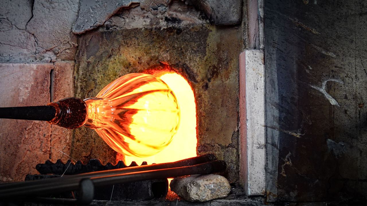 Molten glass glowing at the mouth of a furnace