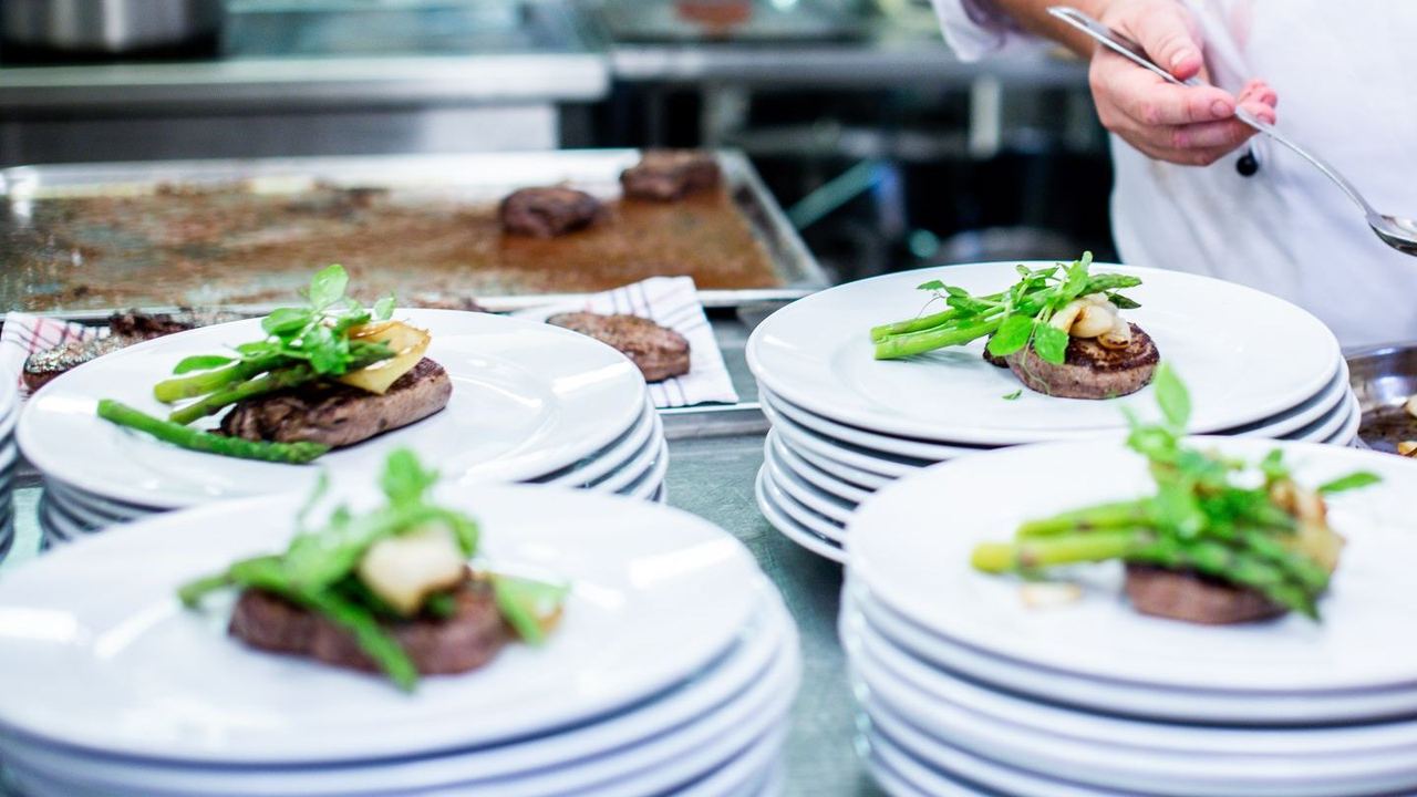 A chef finishing plates in the kitchen