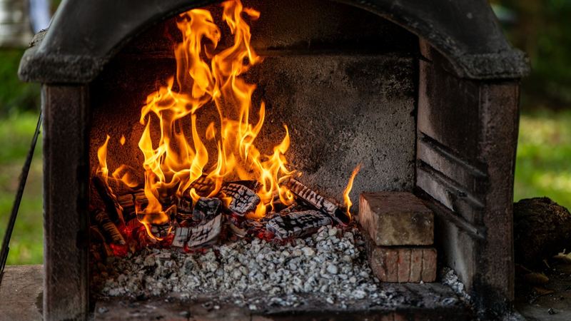 Flames rising from glowing logs in a stone hearth