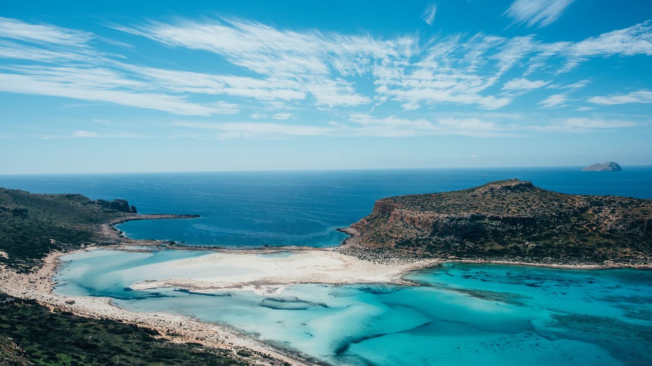 The white sands and turquoise lagoon of Balos, Crete, under a blue sky