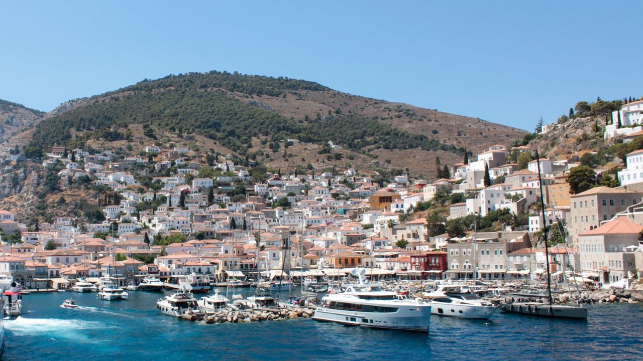 The stone mansions of Hydra rising above the harbour and its yachts
