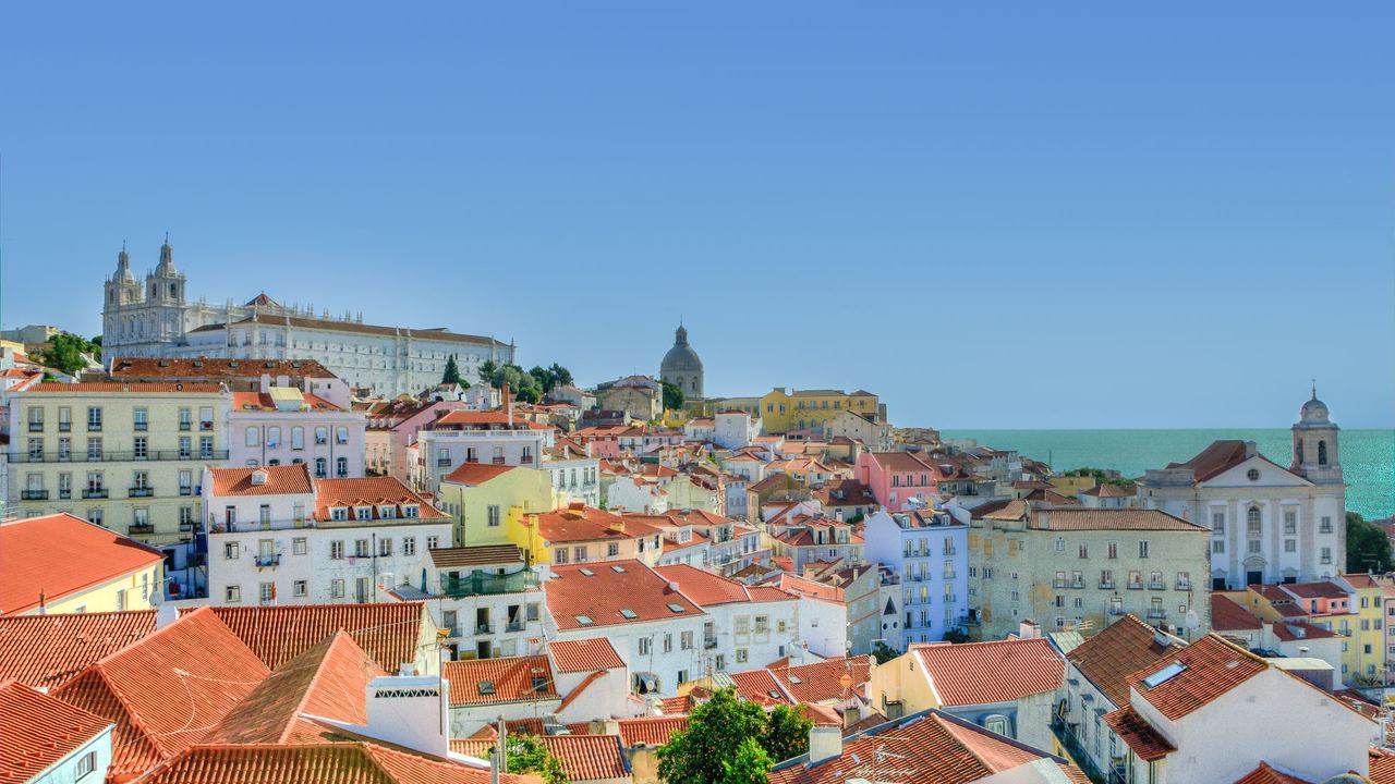 The red roofs, church towers and domes of Lisbon's Alfama running down to the Tagus