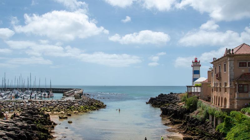 The Cascais marina and the striped Santa Marta lighthouse beside a palace on the rocks