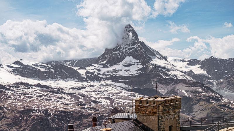 The stone station of the Gornergrat railway, with the Matterhorn rising out of the clouds beyond