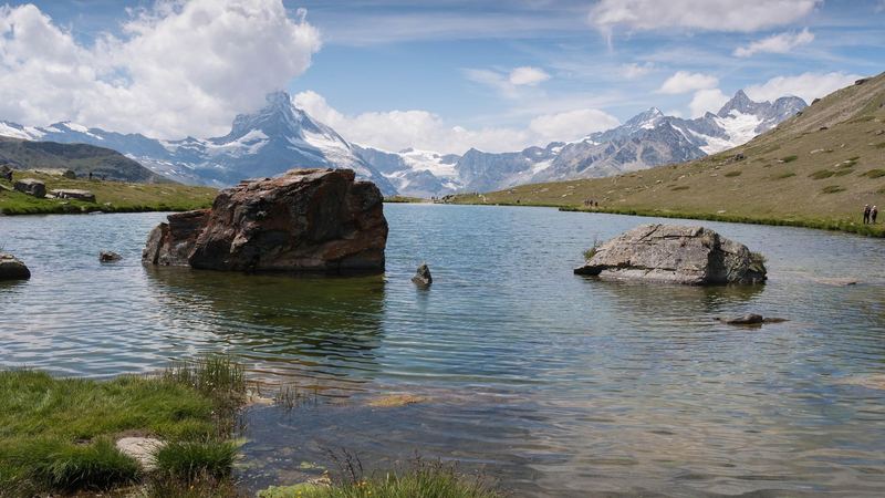 Boulders in the Stellisee lake, the Matterhorn in cloud and the glaciers beyond